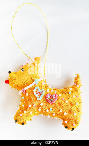 Anno nuovo giocattolo realizzato in tessuto e perline (yellow dog - simbolo del 2018) Foto Stock