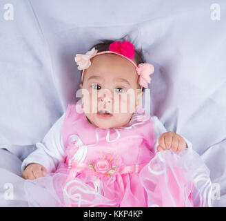 Ritratto di un simpatico neonato ragazza in un abito rosa Foto Stock