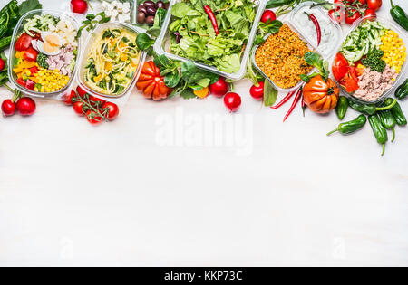 Cibo sano concetto. varietà di insalata di verdure bocce in confezione in plastica bianca su sfondo di legno, vista dall'alto, di confine. salad bar. prenderà il via la dieta Foto Stock