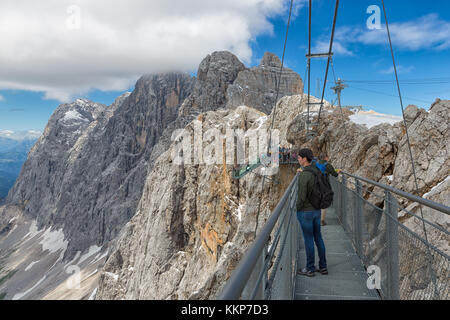 Austriaco monti Dachstein con gli escursionisti il passaggio di una fune di acciaio bridge Foto Stock