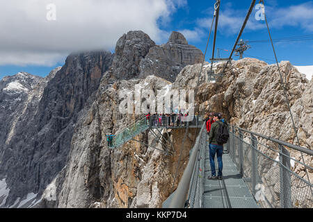 Austriaco monti Dachstein con gli escursionisti il passaggio di una fune di acciaio bridge Foto Stock