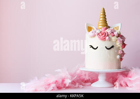 Torta unicorno con glassa rosa e copia spazio a lato Foto Stock