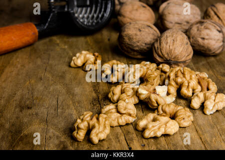 Ancora in vita con gherigli di noce e schiaccianoci sul vecchio pannello di legno Foto Stock