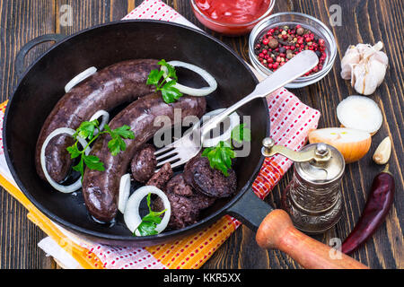 Caldo sangue la salsiccia con la cipolla in padella Foto Stock