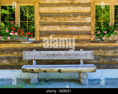 Panca di legno davanti alla cabina di tronchi Foto Stock
