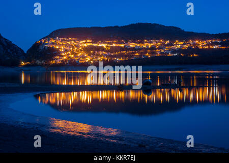 Le luci della città di Barrea si riflette nel lago di Barrea da notte - Abruzzo - Italia Foto Stock