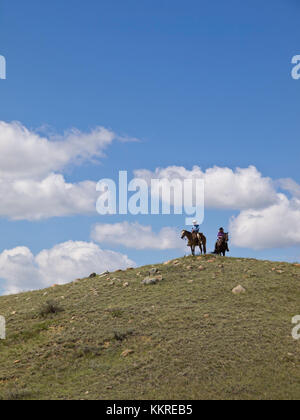 1 uomo e 1 donna a cavallo sulla cima di una collina Foto Stock