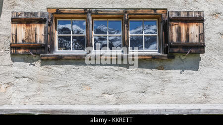 Dettagli della finestra in legno di una tipica casa alpina a Davos, Valle del Sertig, cantone di Graubünden, Svizzera Foto Stock