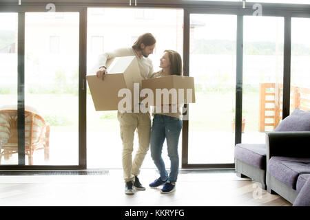 Coppia felice homeowners scatole porta lo spostamento nel nuovo paese h Foto Stock