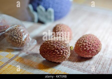 Litchi chinensis sul tavolo, ricoperto con tela cerata Foto Stock