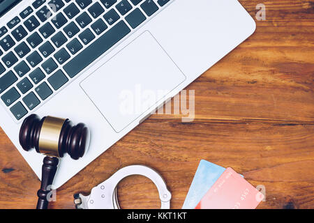Manette, giudice martello e carte di credito sulla tastiera del notebook. Concetto di criminalità su internet, l'hacking, cyber crimini e pagamenti virtuali Foto Stock