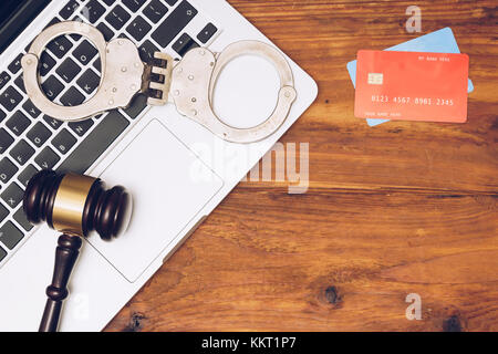 Manette, giudice martello e carte di credito sulla tastiera del notebook. Concetto di criminalità su internet, l'hacking, cyber crimini e pagamenti virtuali Foto Stock