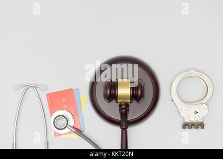 Manette, carte, lo stetoscopio e il martello giudice. Concetto di salute e medicina, negligenza, sistema giuridico. Foto Stock