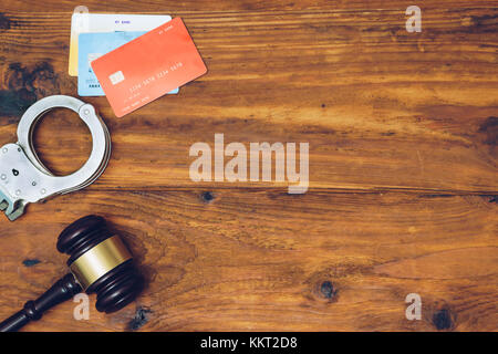 Manette e giudicare il martello e le carte di credito su sfondo di legno Foto Stock
