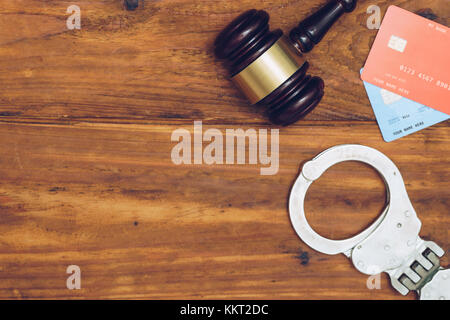 Manette e giudicare il martello e le carte di credito su sfondo di legno Foto Stock