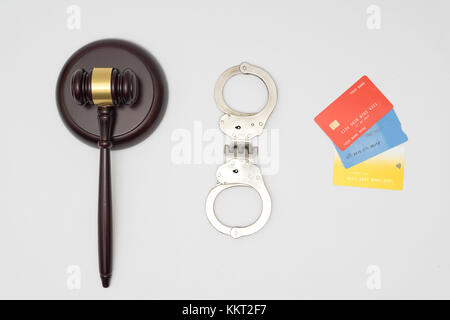 Manette, giudice martello e carte di credito su sfondo bianco Foto Stock