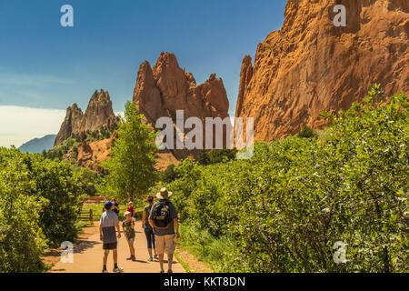 Famiglia a passeggiare nel Giardino degli dèi, Colorado Springs, CO; rosso bizzarre formazioni rocciose sulla destra; blu cielo Foto Stock