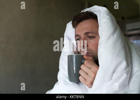 Maschio caucasico con la mancanza di sonno perché ha influenza stting nel letto e chiedere acqua o medicina Foto Stock