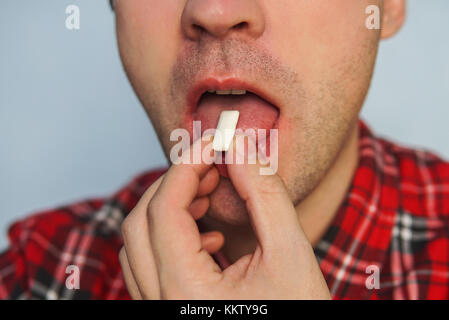 Giovane ragazzo divertente con la gomma da masticare. un alito fresco. alito cattivo. a smettere di fumare utilizzando la gengiva. spazzola verso l'alto. Lavarsi i denti dopo i pasti con gomma. l uomo messo Foto Stock