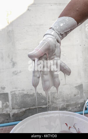 La miscelazione della vernice, la mano con il rosso i colori miscelati, pittori miscelati a mano con colori, dipinta in casa nel lavoro, (selezionare la messa a fuoco a mano) : mani numero di conteggio di FIV Foto Stock