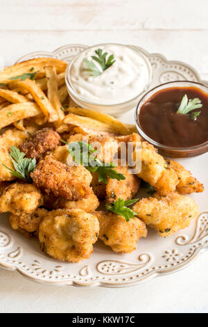 Piastra con Fried Chicken Nuggets e patatine fritte,fuoco selettivo Foto Stock