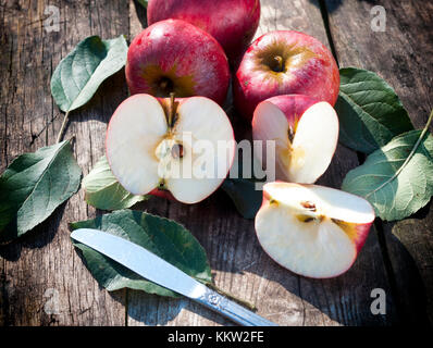 Red mele biologiche sul tavolo di legno.Il fuoco selettivo sulla parte anteriore fette di mela Foto Stock