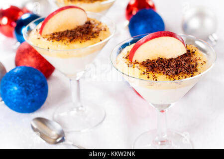 Budino di semolino con cioccolato e Apple in vetro di fantasia.Il fuoco selettivo sul vetro destro Foto Stock