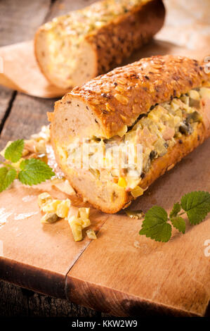 Sub panino farcito con insalata gourment sul pannello di legno Foto Stock