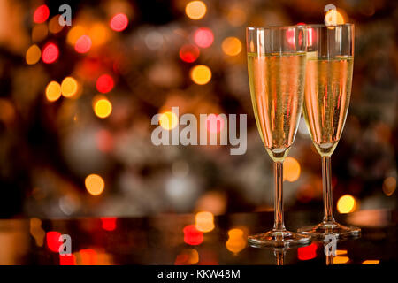 Foto di due champagner bicchieri sul tavolo di vetro con sfondo bokeh di fondo Foto Stock