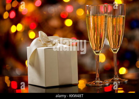 Foto di due champagner bicchieri sul tavolo di vetro con sfondo bokeh di fondo Foto Stock