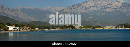 Kemer Antalia bella vista sul mare. Spiaggia Kemer Antalia con sabbia e montagne, il mare con la nave. Bellissimo porto vicino alla spiaggia di sabbia. Foto Stock