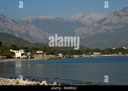 Kemer Antalia bella vista sul mare. Spiaggia Kemer Antalia con sabbia e montagne, il mare con la nave. Bellissimo porto vicino alla spiaggia di sabbia. Foto Stock