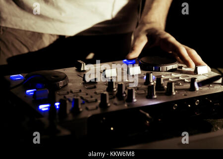 Il dj utilizza una console di mixaggio per gestire la musica elettronic. Foto Stock