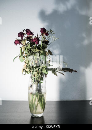 Appassiti mazzo di fiori in un vaso di vetro Foto Stock