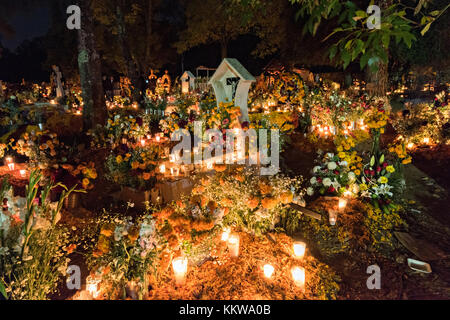 Candele tombe luminose decorate con marigolette e fiori al cimitero di Tzurumutaro durante il giorno del festival dei morti 2 novembre 2017 a Patzcuaro, Michoacan, Messico. La festa è stata celebrata fin da quando l'impero azteco celebra gli antenati e i defunti cari. Foto Stock