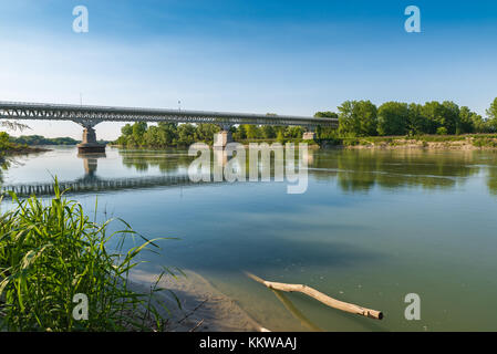 Fiume Po nella cittadina medievale di Piacenza, Italia. Auto ponte che conduce alla città. Il fiume Po è il più lungo fiume italiano Foto Stock