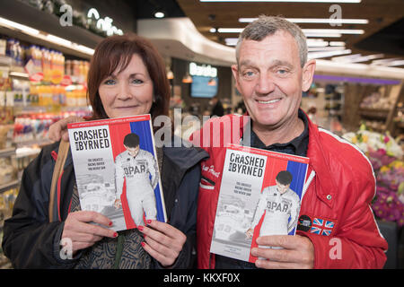 Belfast, Irlanda del Nord. 02/12/2017 - Tommy Byrne, irlandese ex driver di Formula Uno, segni le copie del suo libro "si è schiantato e Byrned' Foto Stock