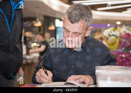 Belfast, Irlanda del Nord. 02/12/2017 - Tommy Byrne, irlandese ex driver di Formula Uno, segni le copie del suo libro "si è schiantato e Byrned' Foto Stock