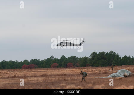 Fort Bragg, NC, Stati Uniti d'America. 2° dic, 2017. dec. 2, 2017 - Fort Bragg, n.c., Stati Uniti d'America - US Army uh-60 Black Hawk elicottero vola in sicilia nella zona di caduta dei paracadutisti come raccogliere i loro paracadute al ventesimo annuale di randy oler memorial il funzionamento del giocattolo drop, ospitato da esercito degli Stati Uniti per gli affari civili e le operazioni psicologiche il comando (airborne). La manifestazione annuale, classificato come il più grande del mondo di combinata airborne operazione con i paracadutisti da nove nazioni alleate, consente di paracadutisti l opportunità di aiutare i bambini nelle comunità che circondano Fort Bragg ricevere Donati giocattoli per le vacanze di Natale. (Credi Foto Stock