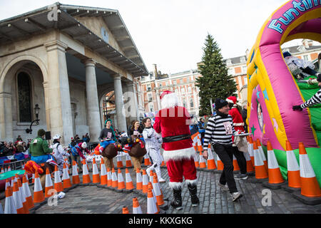 Londra, Regno Unito. 2 dicembre, 2017. I membri delle squadre di sei, ogni vestito in abiti fantasiosi e portante un pudding natalizio su un vassoio, la battaglia per vincere il pudding natalizio trofeo durante il grande pudding natalizio gara a covent garden in aiuto del Cancer Research UK. Credito: mark kerrison/alamy live news Foto Stock