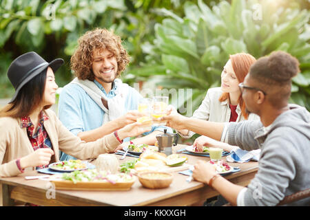 Happy amici tostare con limonata fatta in casa servita su tavolo da colazione Foto Stock