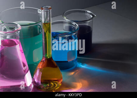 Elevato angolo di visione della vetreria da laboratorio con prodotti chimici liquidi isolate su uno sfondo grigio Foto Stock
