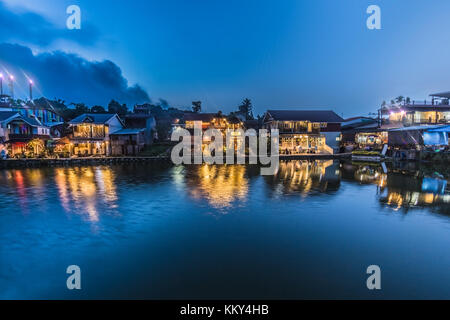 Scenario. vista sul bellissimo lungomare di villaggio in scena notturna hanno luce da casa con scuri sono in background Foto Stock