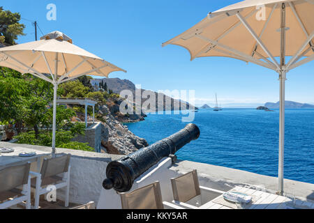 Ristorante sul mare appena fuori città Hydra guardando ad ovest lungo la costa, Hydra, Isole Saroniche, Grecia Foto Stock