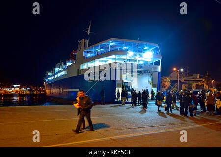 Ruolo sul ruolo off traghetto per Aegina durante la notte nel porto di Pireo di Atene, Grecia, con lo sbarco di passeggeri e veicoli Foto Stock