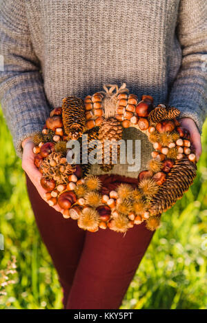 Donna che mantiene ghirlanda autunnale, dettaglio Foto Stock