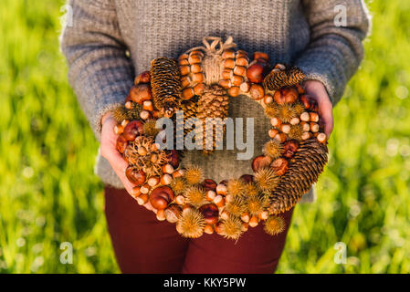 Donna che mantiene ghirlanda autunnale, dettaglio Foto Stock