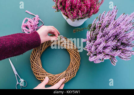 Fai-da-te, donna, dettaglio, mani, decorazione autunnale, Willow corona, Heather Foto Stock