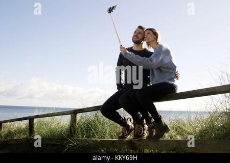 Giovane, mar baltico, a piedi, corrimano, sedersi selfie, Foto Stock