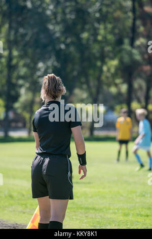 Arbitro assistente mantenendo un occhio attento sui giocatori di calcio per assicurarsi che non siano fuorigioco Foto Stock
